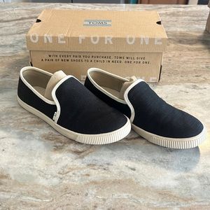 Tom’s black and white canvas slip on shoes.